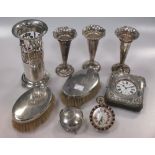 A collection of silverware including three loaded vases, a pierced vase, a pair of brushes, and a