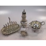 A silver toastrack, a silver cream jug, a silver caster and a silver tea strainer, 14.4 ozt gross (