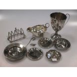 A silver two handled cup, a silver sauce boat, a silver toast rack, a silver armada dish with