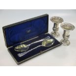 A pair of sliver vases with loaded bases, and a cased pair of silver serving spoons with gilded