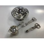 A silver tea strainer, a pair of silver grape shears, a silver bon bon dish and a pair of silver