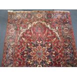 A red ground rug with central floral design, 188 x 145cm