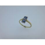 An Art Deco sapphire and diamond ring, the two square facetted sapphires millegrain set vertically