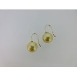 A pair of golden coloured pearl earpendants, each a 12.5mm probably freshwater cultured pearl of