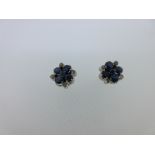 A pair of sapphire and diamond cluster earstuds, designed as a pierced quatrefoil of round cut