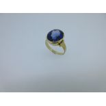 A single stone synthetic sapphire ring, the oval cut royal blue sapphire set in a deep recessive