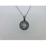 An aquamarine and diamond pendant on a chain, the round facetted aquamarine in a millegrain edged