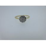 A diamond flowerhead cluster ring, the round brilliant cut diamond, millegrain collet set in the