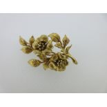 An 18ct gold flower spray brooch by Cropp & Farr, designed as a realistically modelled single stem