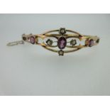 A pink tourmaline and seed pearl hinged bangle, the open and shaped front section set with three