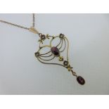 An Edwardian garnet and seed pearl pendant on chain, the wirework pendant of pierced and foliate