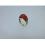 A coral and diamond dress ring, the high domed cabochon crescent of salmon pink coral set between