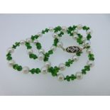 A green diopside and cultured pearl necklace, the facetted vivid green diopside beads hand-knotted