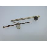 A diamond bar brooch and an opal one, the first a plain narrow bar with a raised ball part way along
