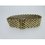 A 9ct gold cuff bracelet, composed of uniform spaced brick links to a concealed clasp with twin
