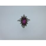 A marquise ruby and diamond cluster ring, the marquise cut ruby in a petal-edge border of twelve