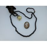 A garnet bead necklace together with a heart-shaped locket and a cameo pendant / brooch, the