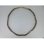 A fancy link necklace, comprising alternating short lengths of textured byzantine link chain and