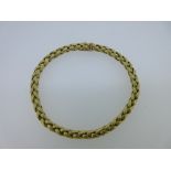 An 18ct gold bracelet, composed of textured woven links, to a masked push in box snap and figure