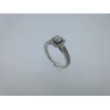 A modern diamond cluster ring set in 18ct white gold, the central claw set round brilliant cut