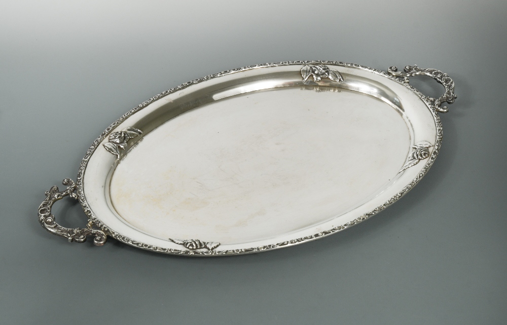 A German metalwares oval tray, by Handarbeit, with floral border and two applied scrolling