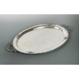 A German metalwares oval tray, by Handarbeit, with floral border and two applied scrolling