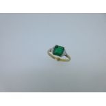 An emerald and diamond 3 stone ring, the square emerald cut emerald between two kite shaped