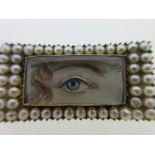 A pearl set lover's eye brooch, the rectangular painting depicting a blue eye under a delicately