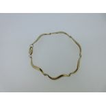 Christopher Wharton - A 9ct gold bracelet, of polished solid articulated lazy S links, to a