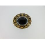 A Victorian banded agate and enamel brooch, the oval banded agate collet set to a ropetwist base and