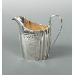 A George III silver cream jug, by Thomas Wallis II, London 1799, of oval panelled form, heavily