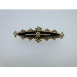 An onyx and pearl set memorial bar brooch, the central concave navette shaped onyx topped with an