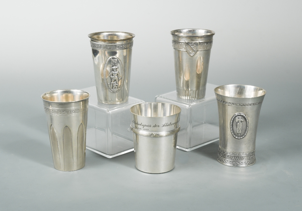 A collection of five Swiss metalwares tumblers, of conical form with applied wording relating to