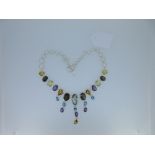 A modern multi gem set fringe necklace, composed mainly of variously coloured quartzes, with a