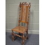 A Carolean style oak standard chair with decorative cresting, having cane panel back and seat,