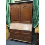 A Georgian oak bureau/bookcase, the upper part fitted shelves and drawers enclosed by a pair of