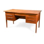 A Danish teak desk, the rectangular top above a central frieze drawer flanked by three further