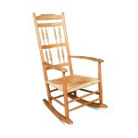 A Neville Neal ash rocking chair, after a design by Ernest Gimson, with a spindle turned back and