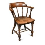 In the manner of E. W. Godwin for James Peddle, an Aesthetic period oak elbow chair, the curved back