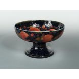 A large Moorcroft Pomegranate pattern pedestal fruit bowl, the circular bowl raised on a spreading