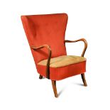 In the manner of Søren Hansen, a 1950s Danish wing-back armchair, the red upholstered back and sides