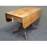 Regency mahogany pembroke table on platform base having four sabre legs with brass castors, 105cm