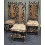 A set of six Carolean style carved oak dining chairs decorated with scrolling and other motifs,