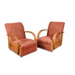 A pair of Art Deco oak framed armchairs, each with reeded curvaceous open arms and overstuffed