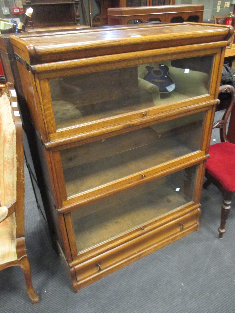 A pair of medium oak Globe Wernicke 3 section stacking bookcases with a drawer to the plinth base