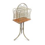 A late Victorian mahogany and brass revolving magazine rack, the brass frame with wirework