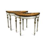 A pair of Sheraton revival painted satinwood demi-lune tables, with a parcel gilt painted frieze and