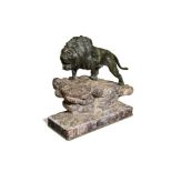 A 19th century bronze model of a lion, on a naturalistic rock work base and mounted on a rouge