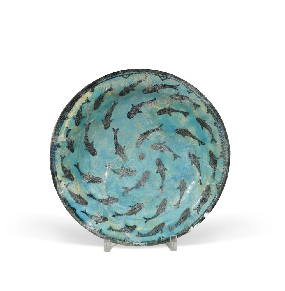 An Iranian pottery dish, probably 13th/14th century, the turquoise body decorated in black with