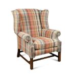 A George III style mahogany wing back armchair, upholstered in a chequered linen fabric, on